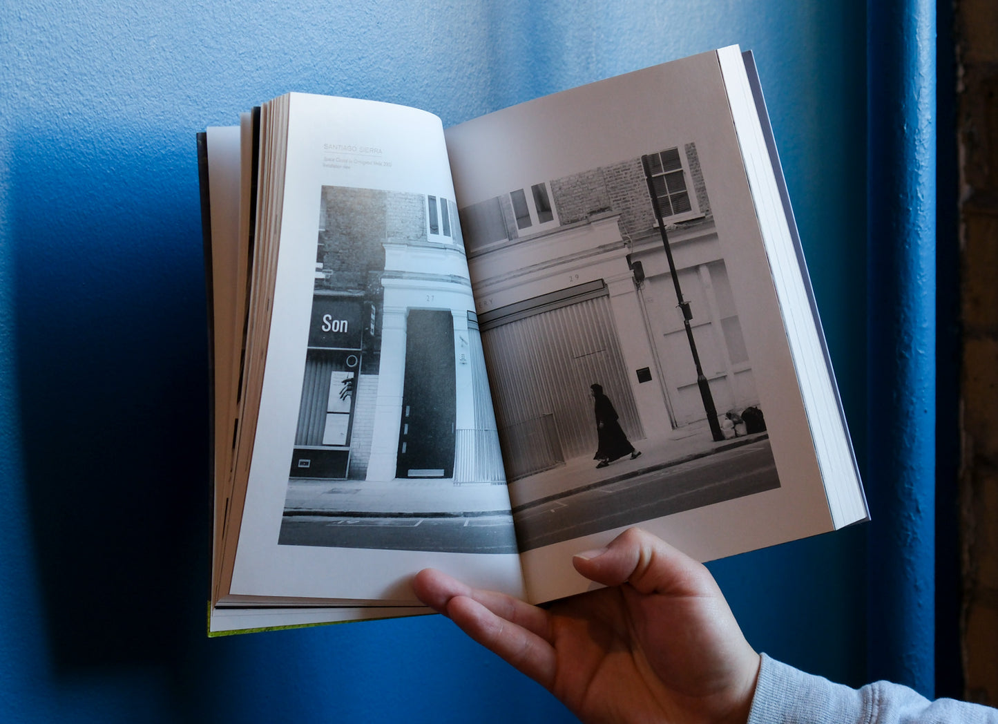 Open book with black and white photos on a blue surface