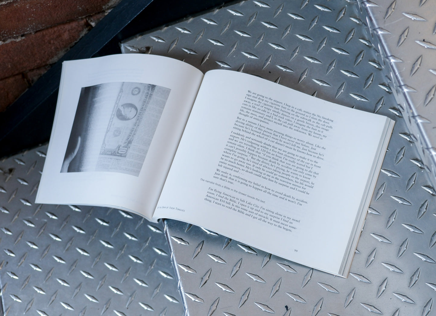 Open book with text and a photo on a metallic surface