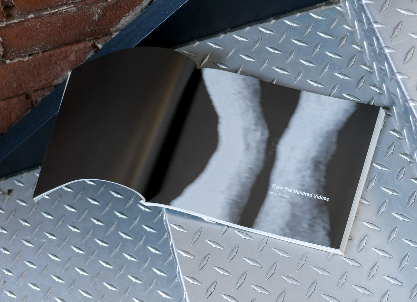 Book with a black and white interior on a metallic surface