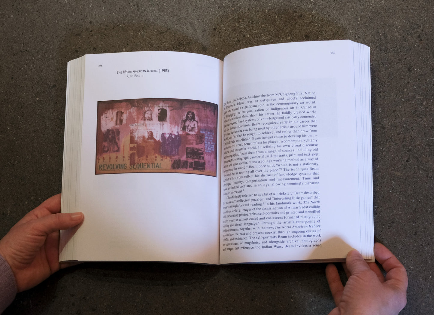 Open book held by hands on a dark surface