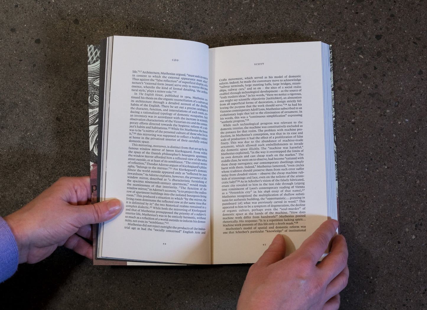 Open book held by a person on a dark textured surface