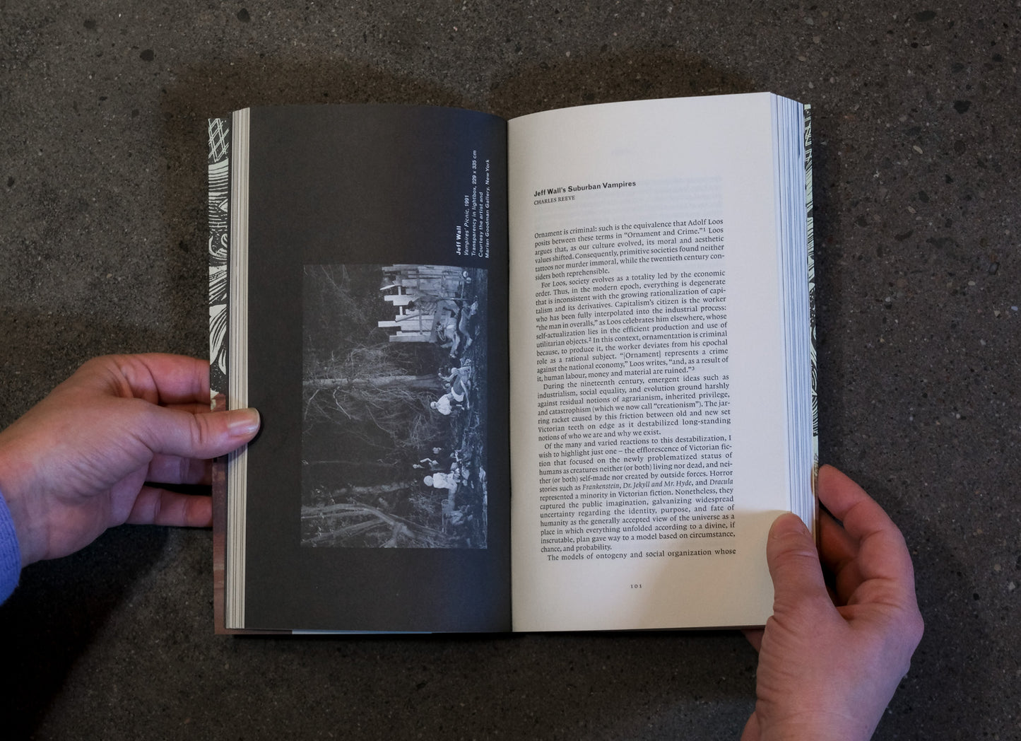 Open book held by a person on a dark surface