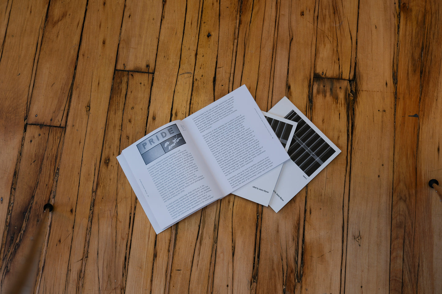 Open book and newspaper on a wooden floor