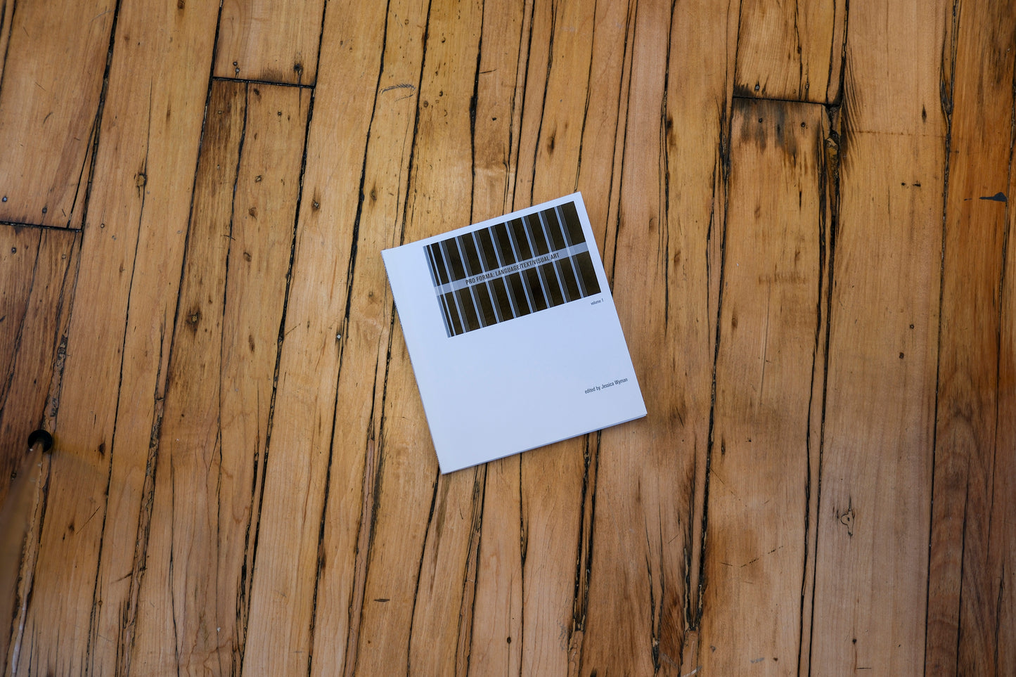 White book cover with black design on a wood background