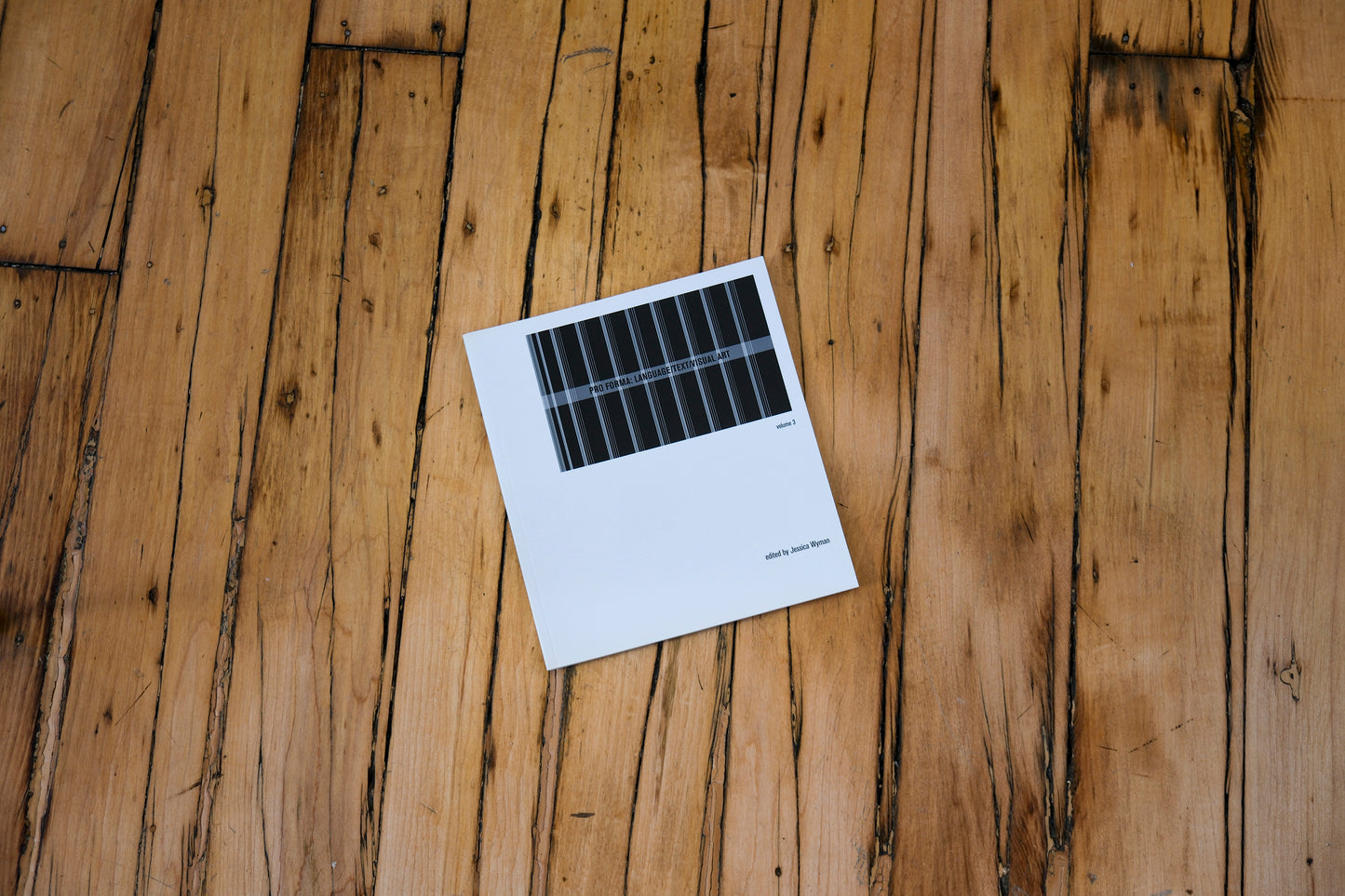 White book coverr with black text on a wooden surface