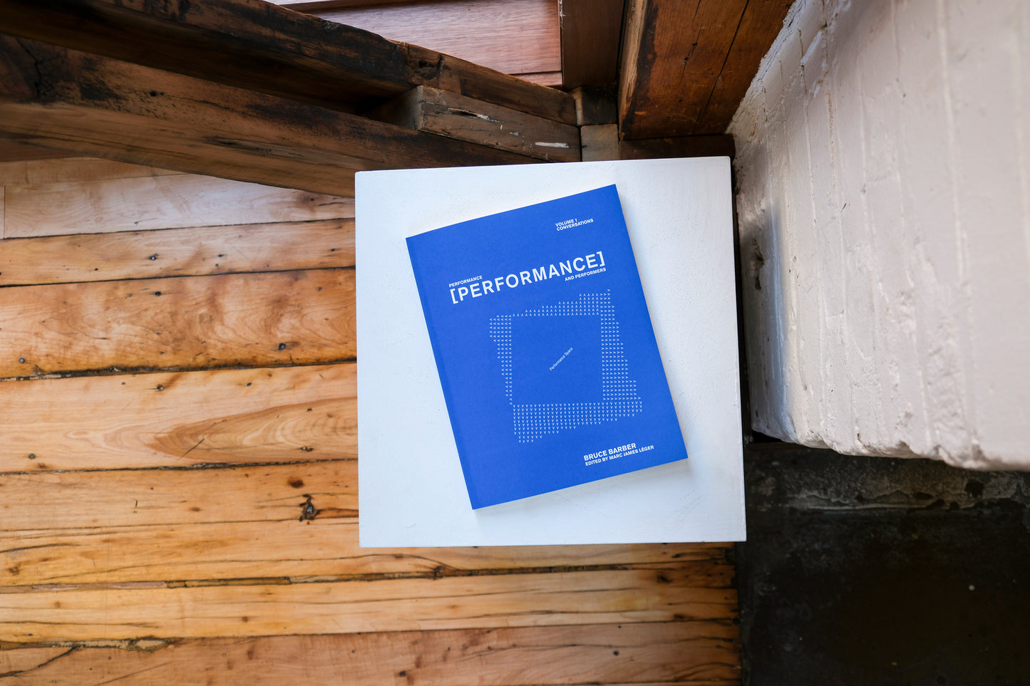 Blue and white box titled 'Performance' on a plinth on a wooden surface