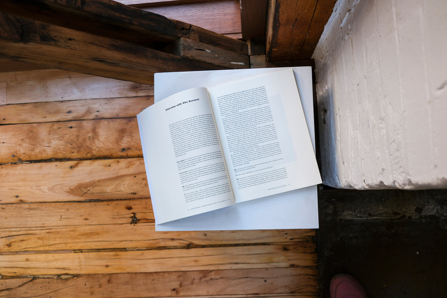 Open book on a plinth on a wooden surface with a rustic background