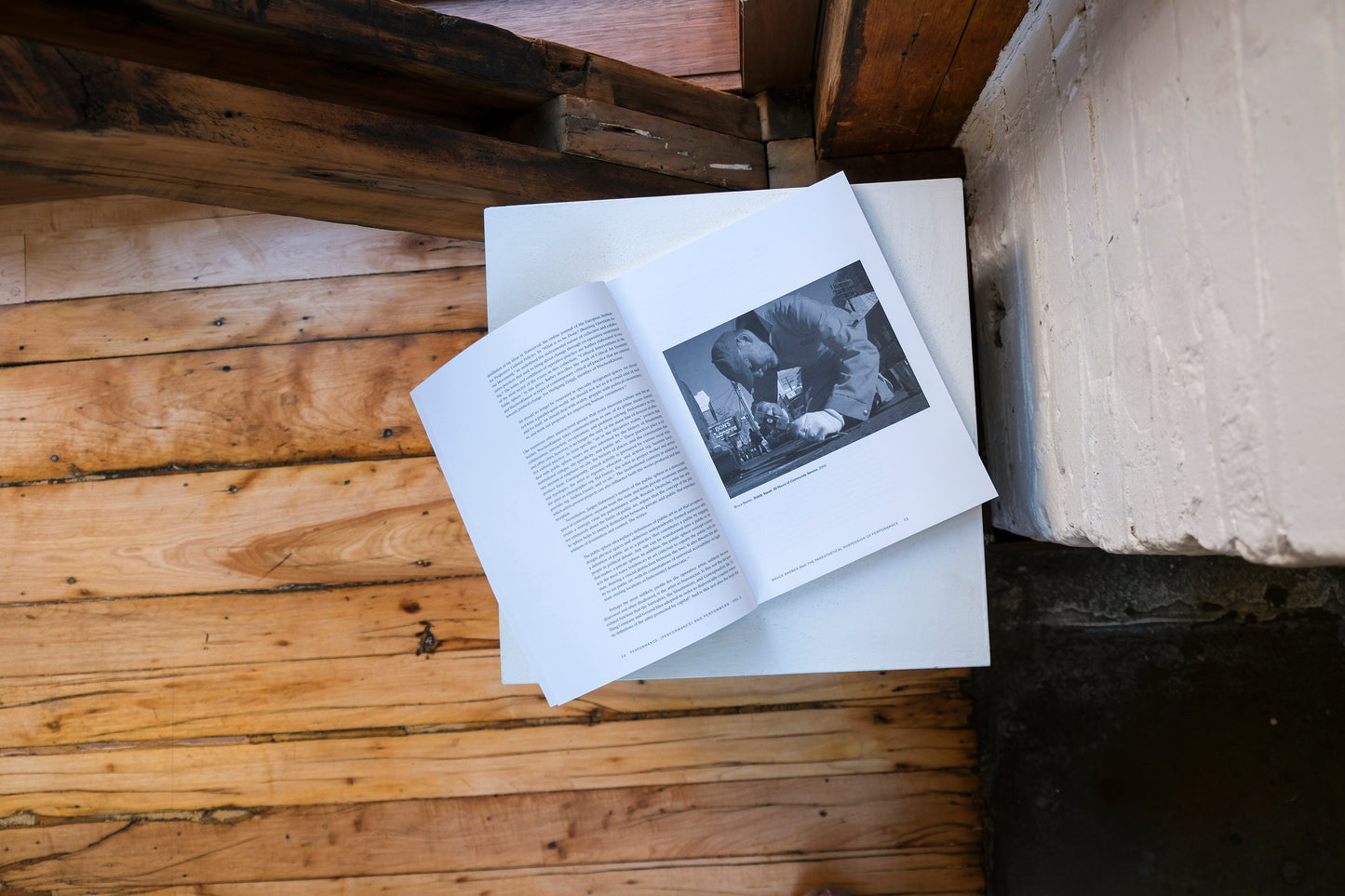 Open book with black and white photo on a plinth on a wooden surface