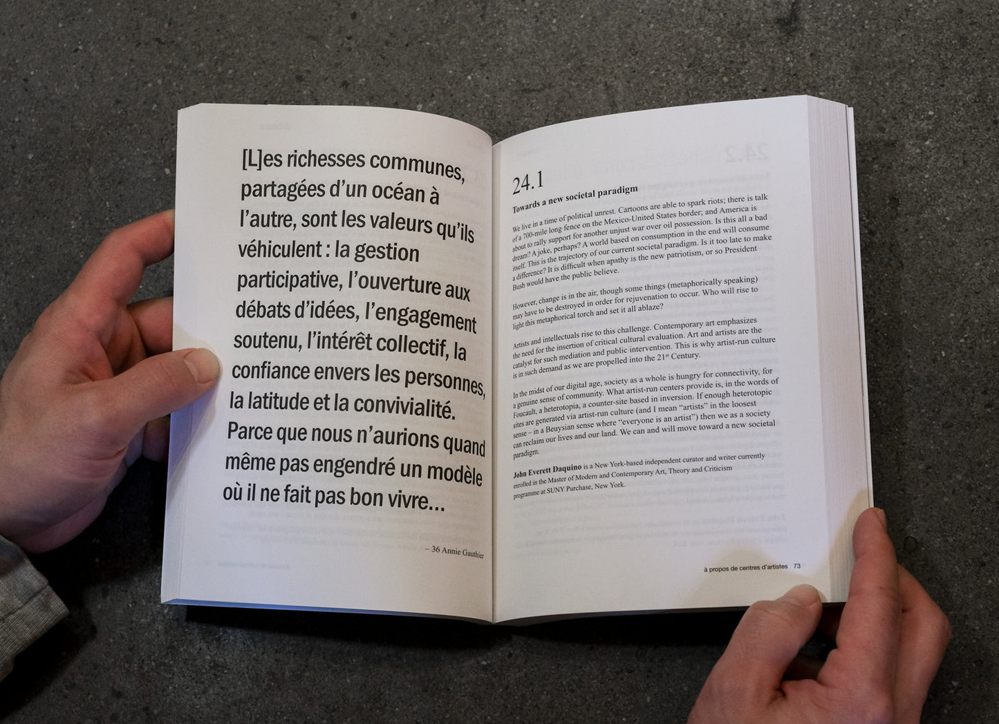 Open book held by hands on a dark surface