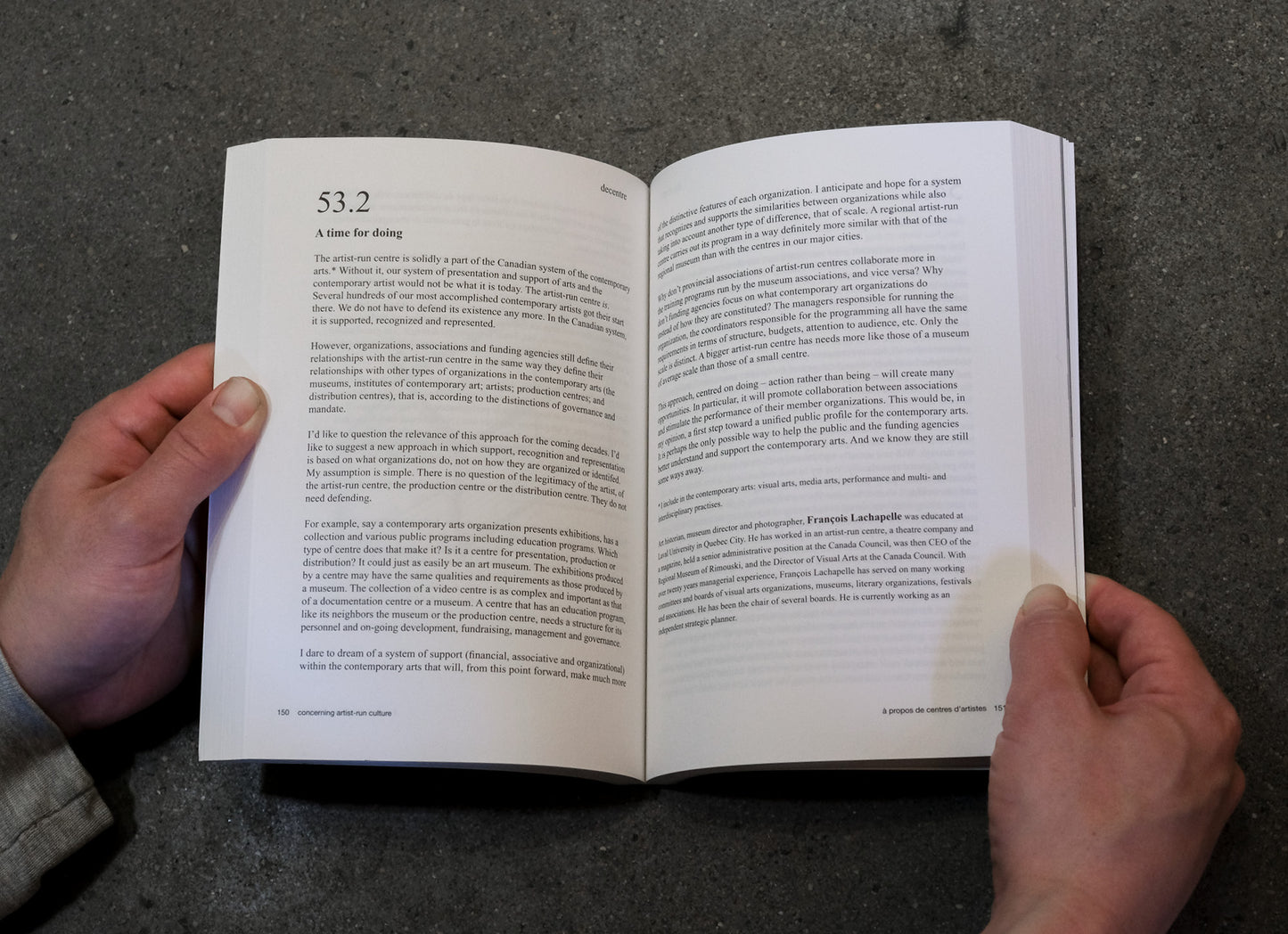 Open book held by hands on a dark textured surface