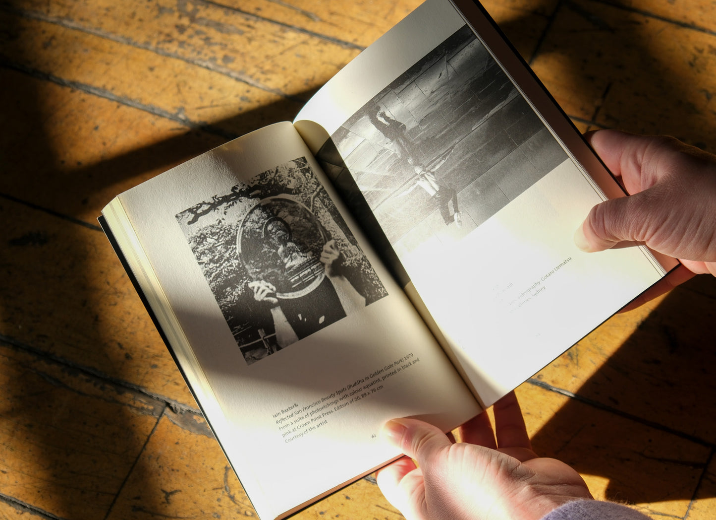 Open book with black and white photos on a wooden surface