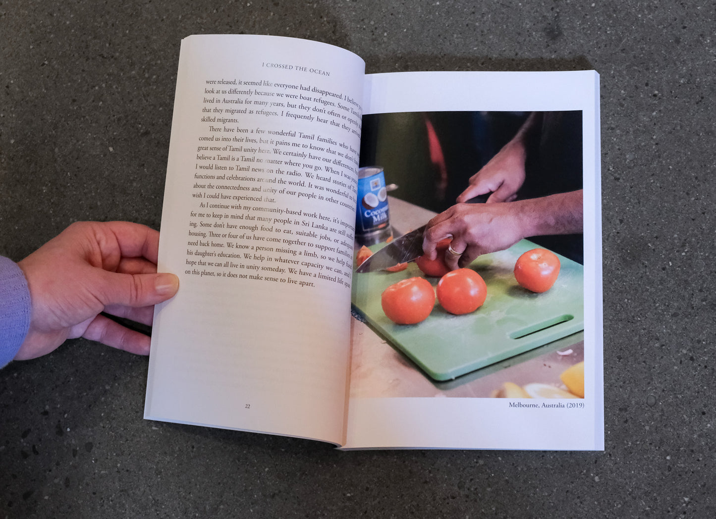 Open book showing a photograph of hands cutting tomatoes on a green cutting board.