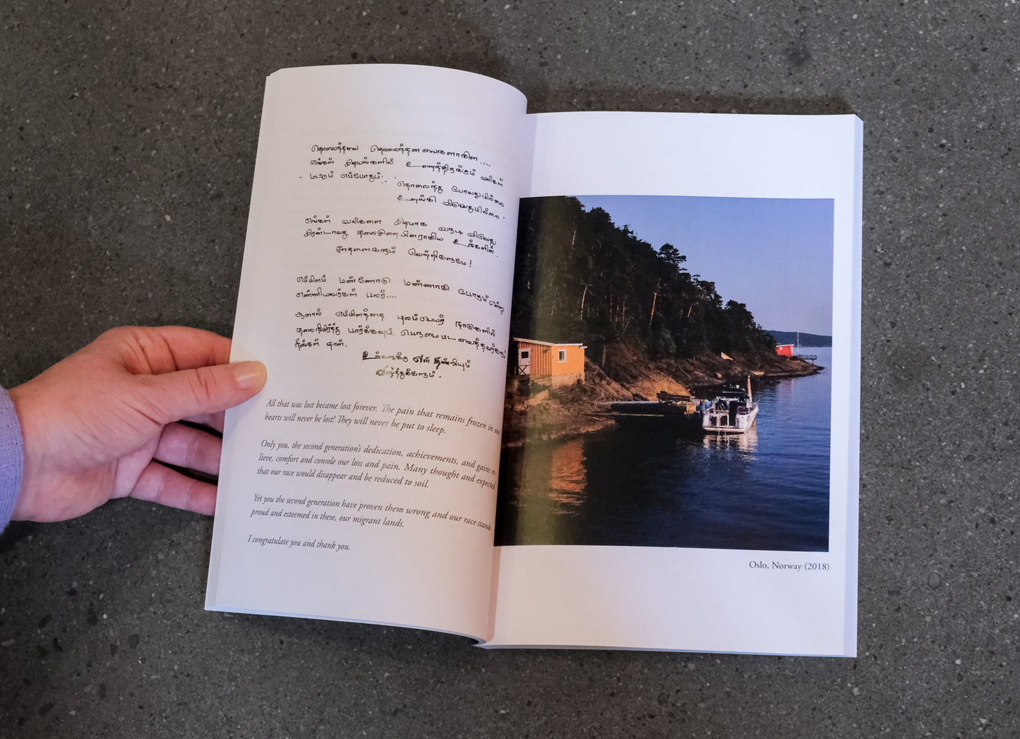 Open book with text and a photograph of a coastal scene on a dark surface