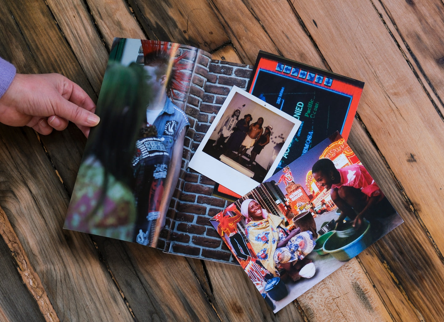 Open book and with photos on a wooden surface with various postcard photos inside