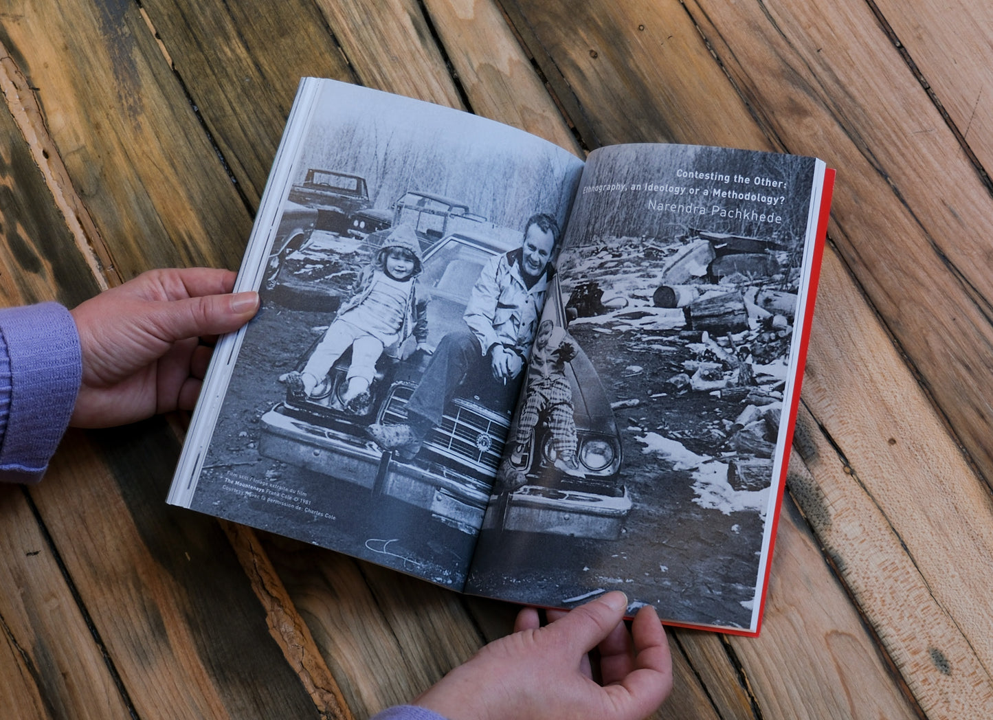 Open book with black and white photos on a wooden surface