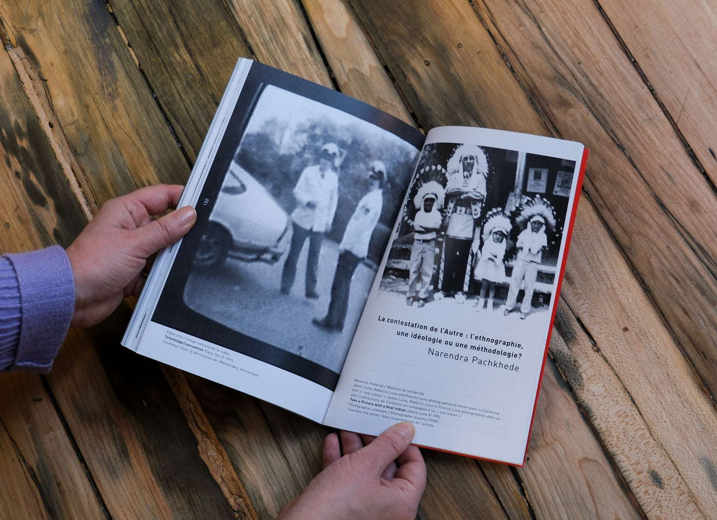 Open book with black and white photos and text on a wooden surface