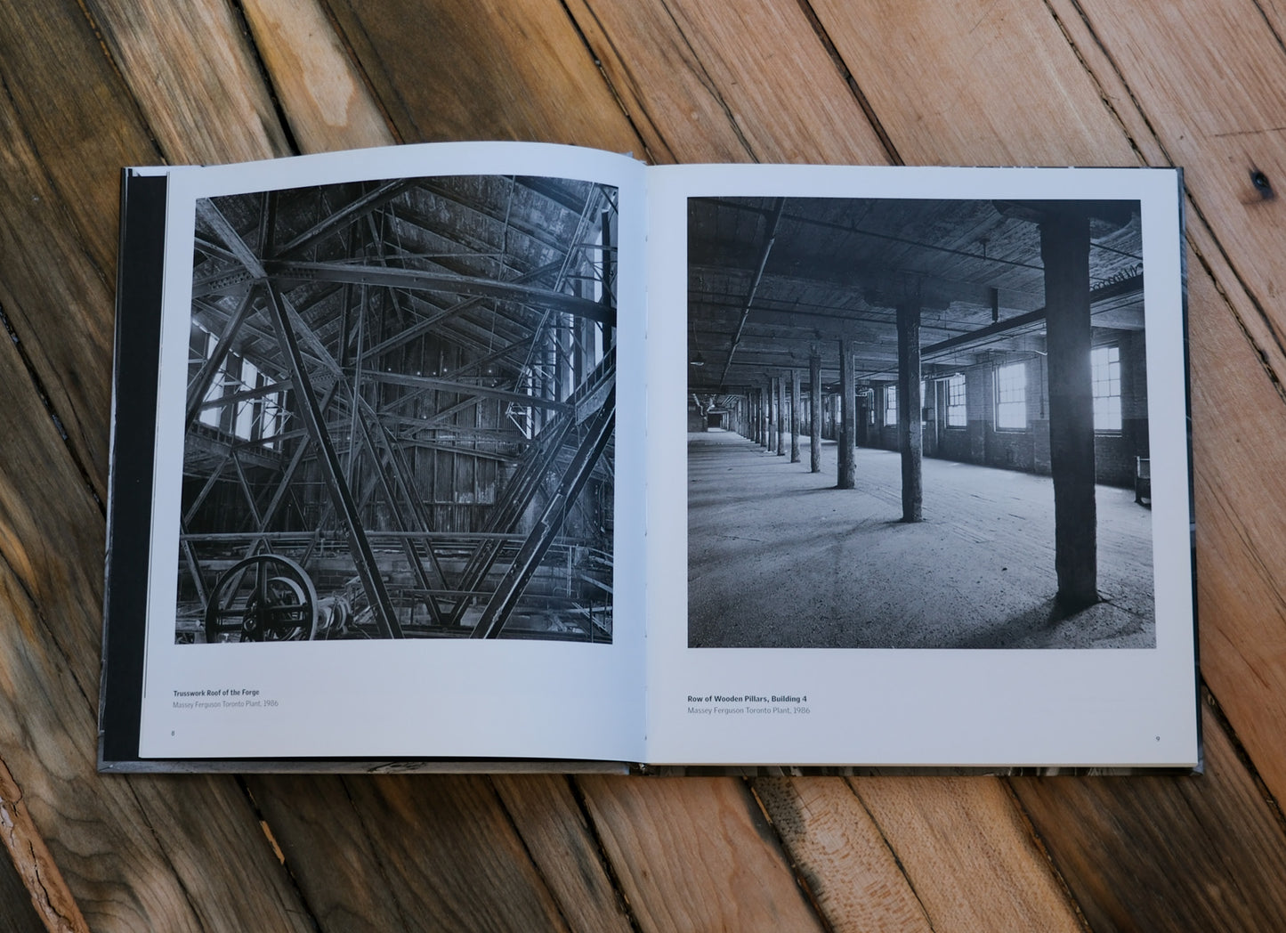 Open book showing black and white photos of industrial interiors on a wooden surface