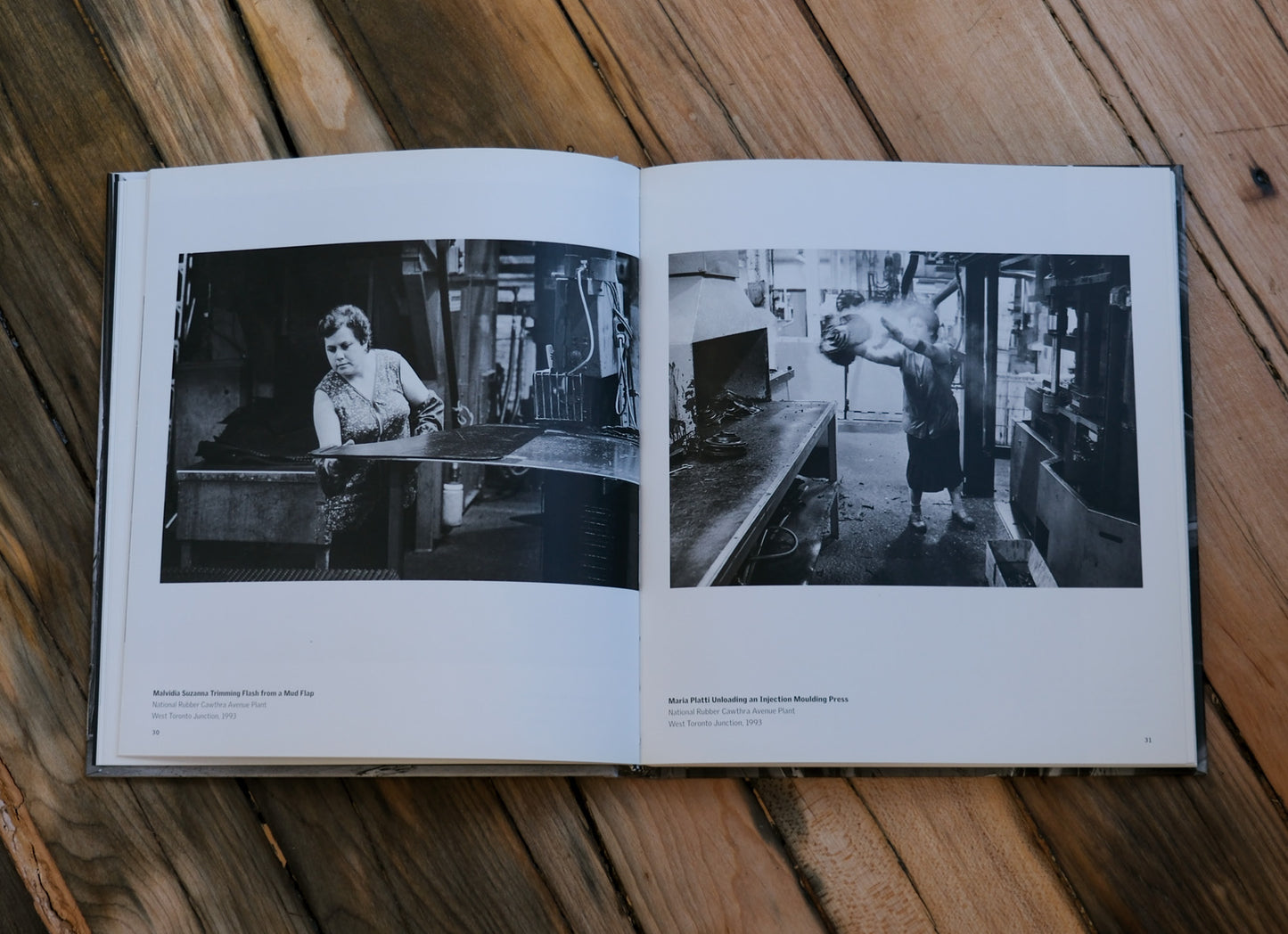 Open book with black and white photographs on a wooden surface