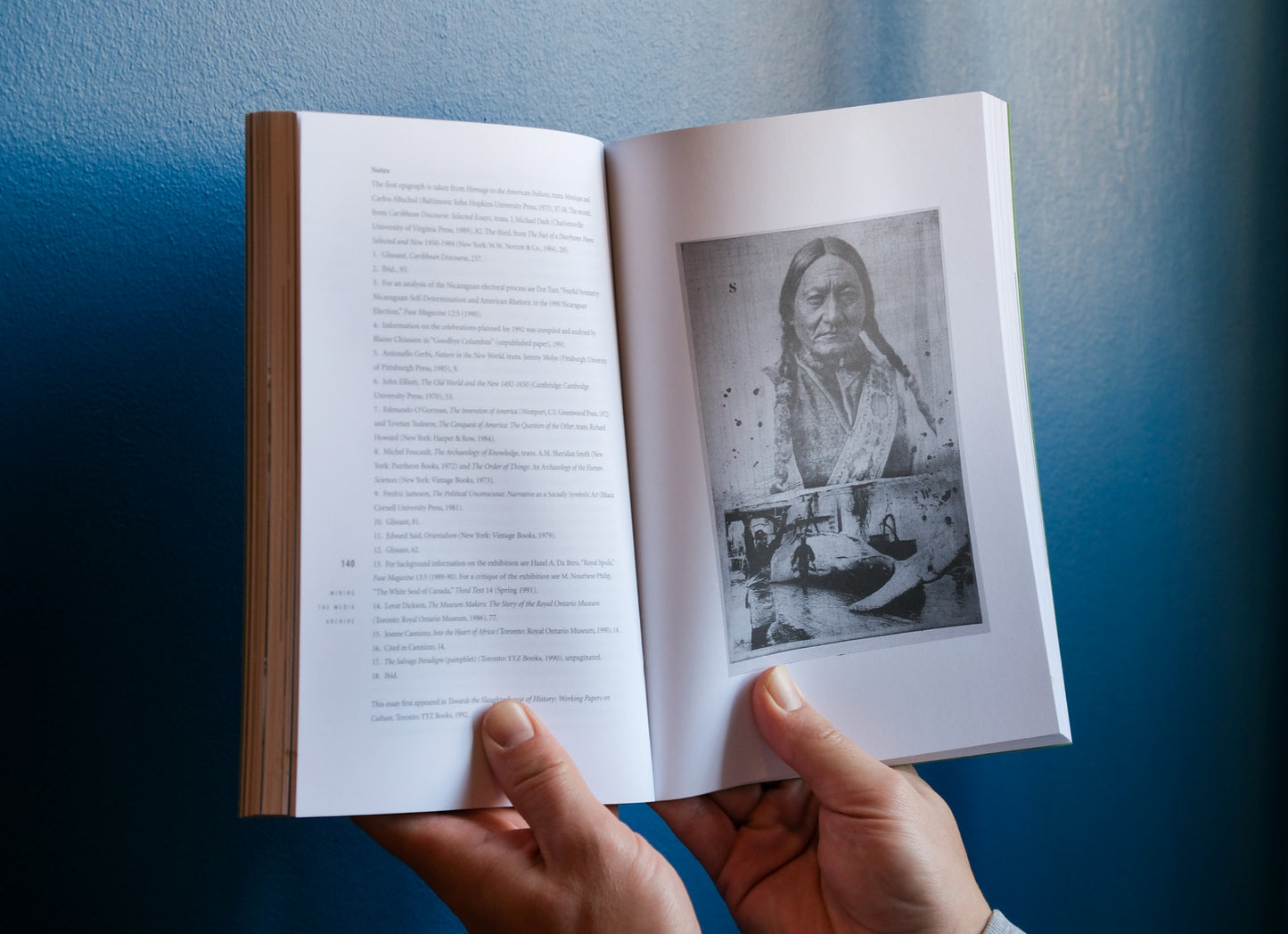 Open book with a black and white photo on held against a blue background