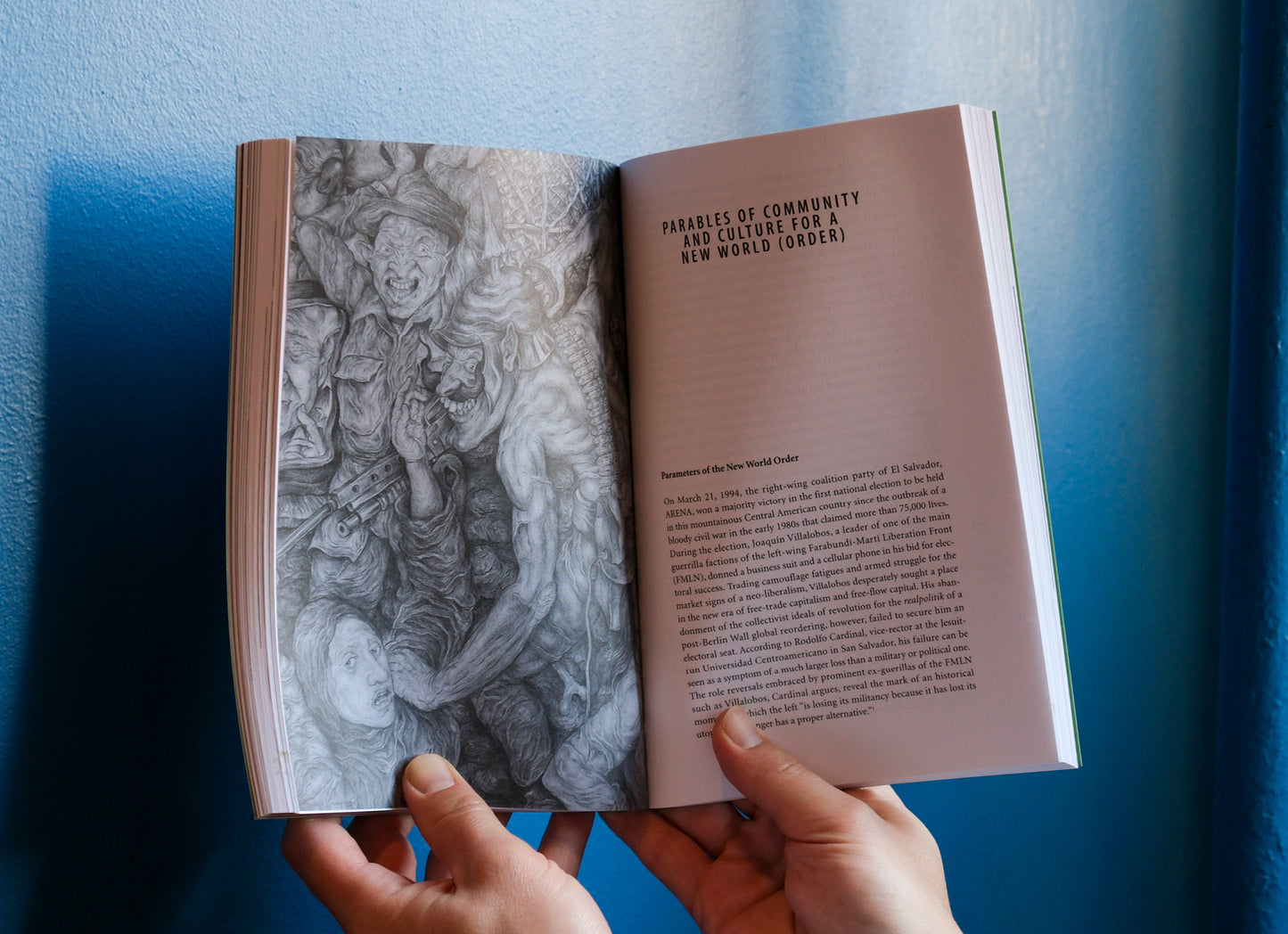 Open book with illustrations and text held against a blue background