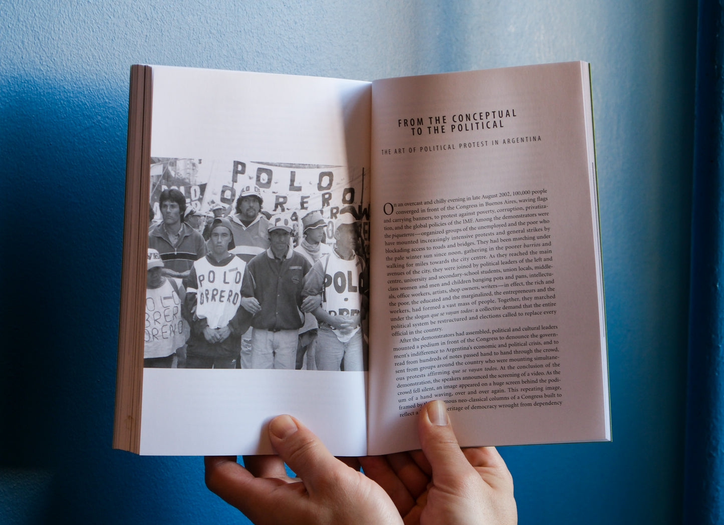 Open book with a photo and text held against a blue background