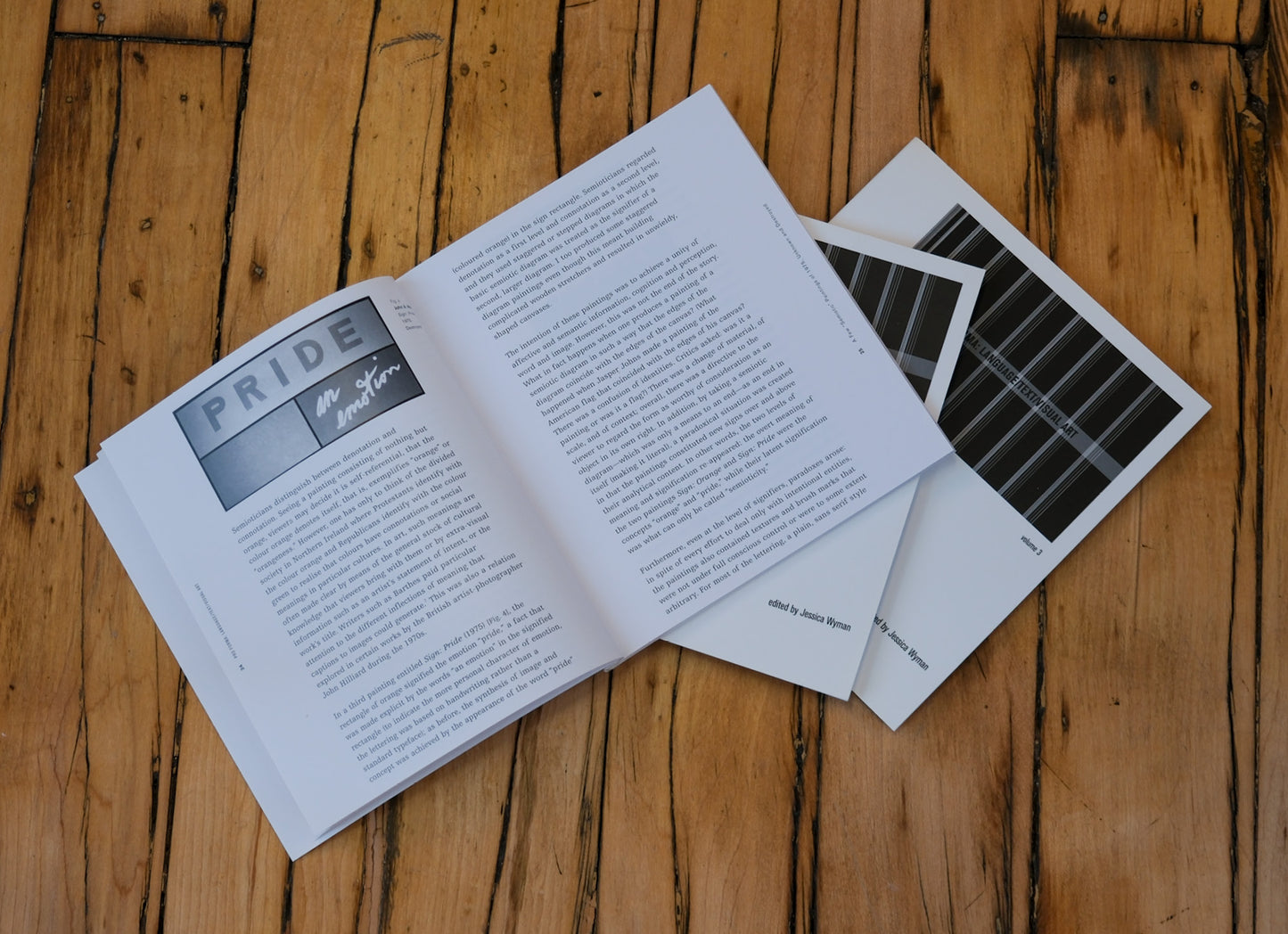 Open book with 'Pride' magazine on a wooden surface