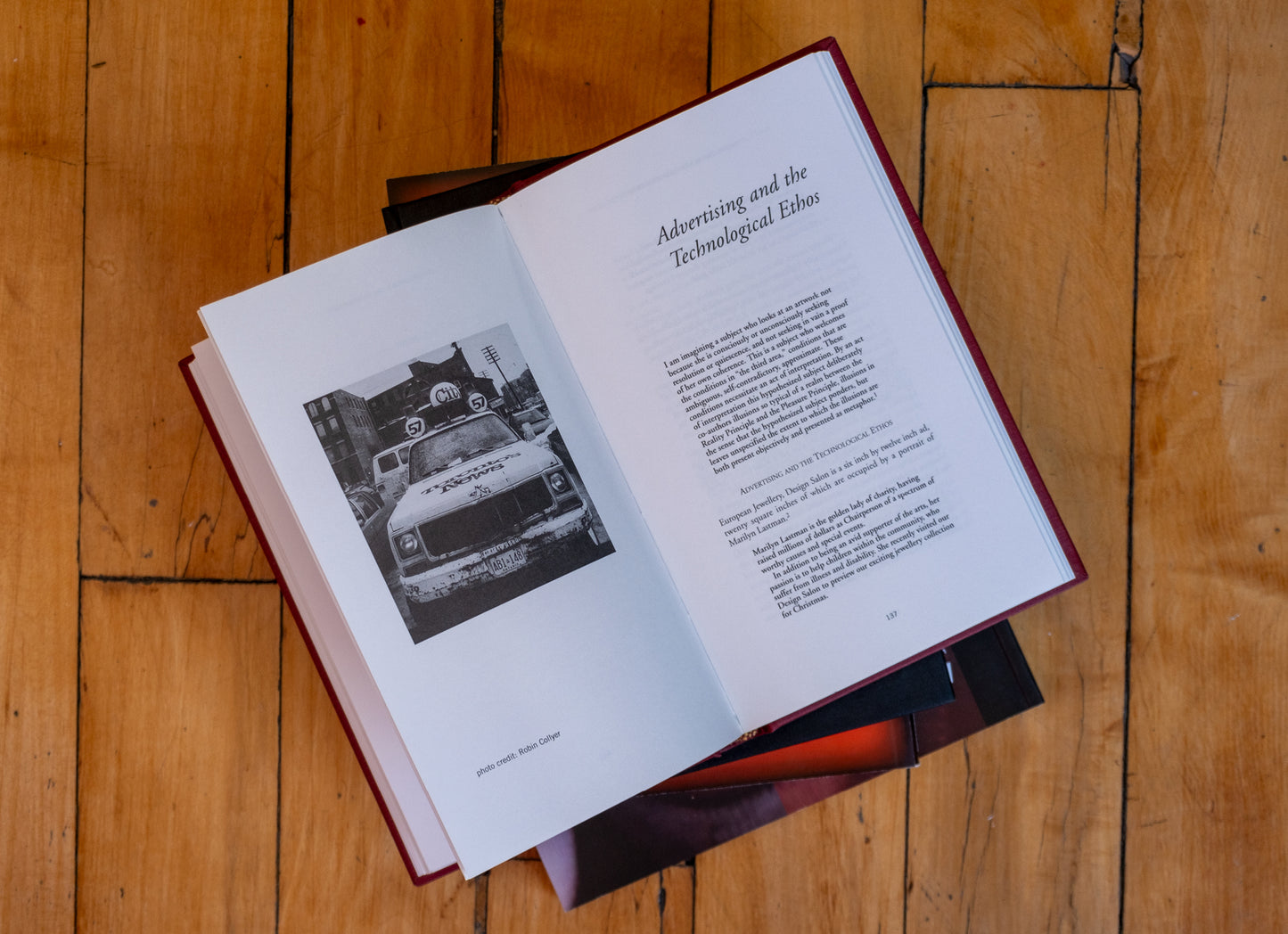 Open book on a wooden surface with text and a black and white photo.