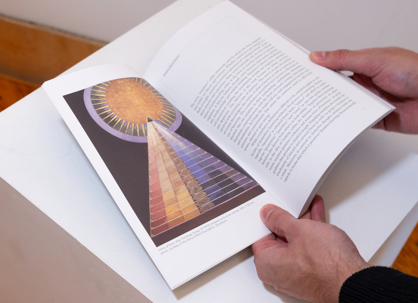 Reader holding open Technologies of Intuition show pages