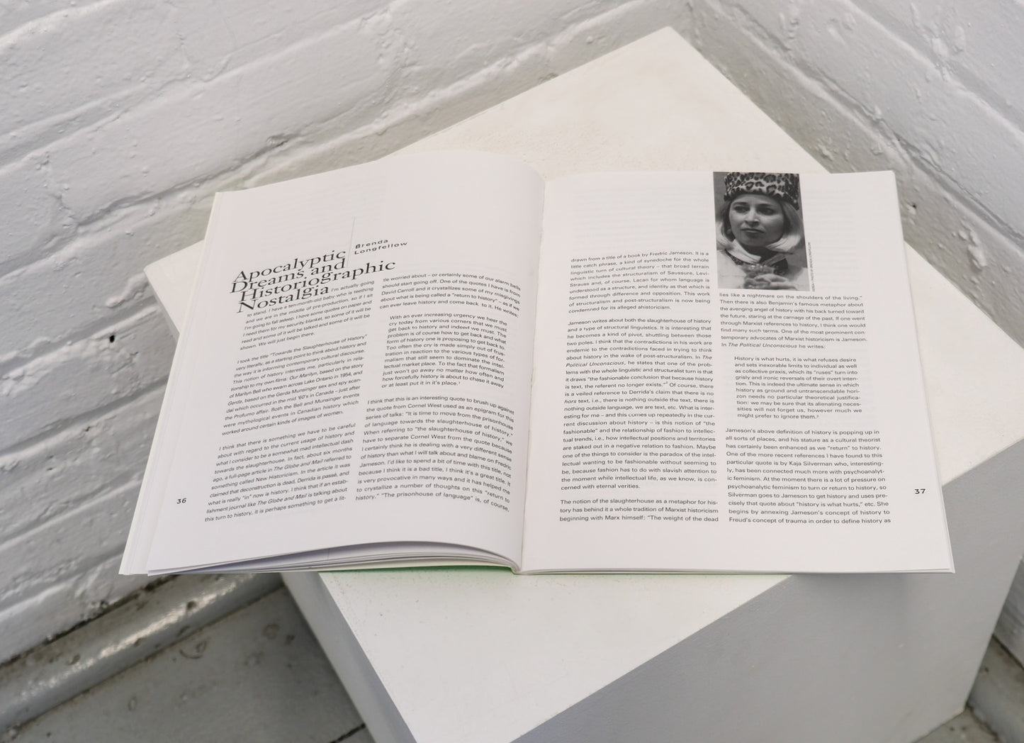 Open book with text and a photo on a white surface