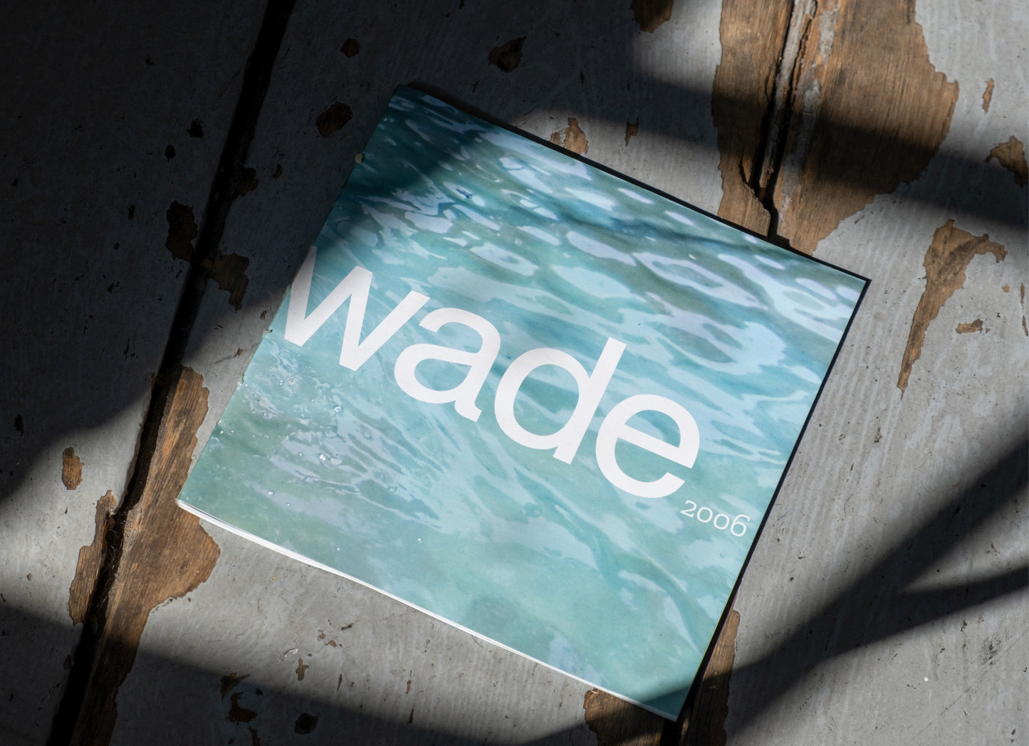 Wade Catalogue cover on a wood floor with moody shadows