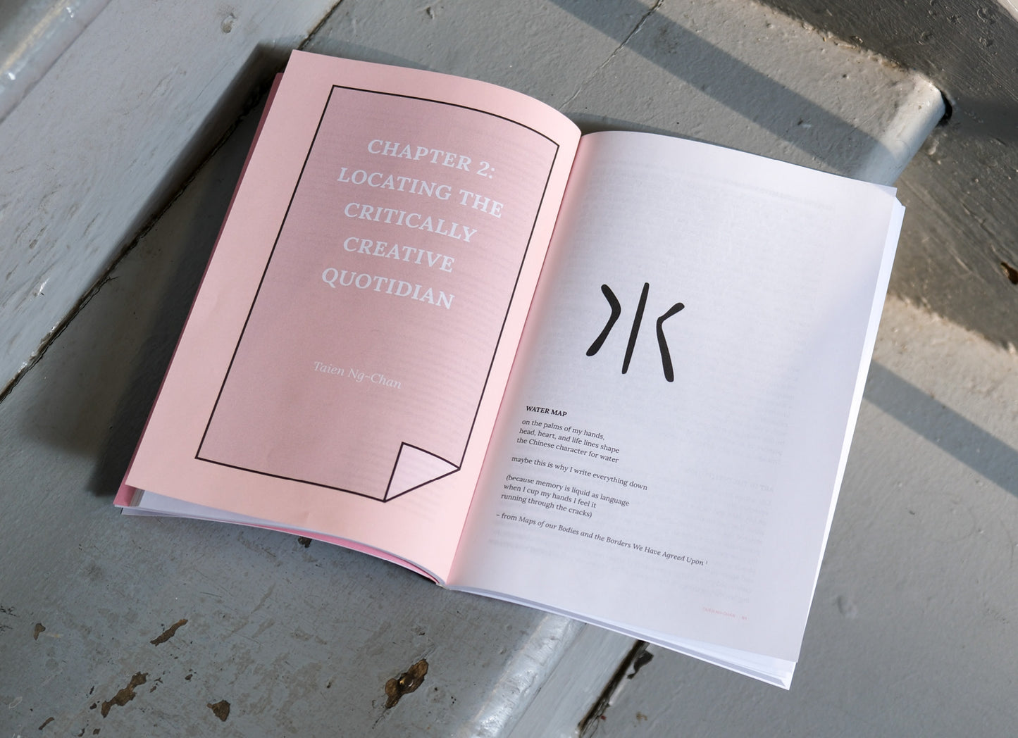 Open book with pink and white pages on a gray surface